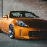 Auto gialla leggermente modificata con assetto ribassato e cerchi sportivi, parcheggiata all’aperto