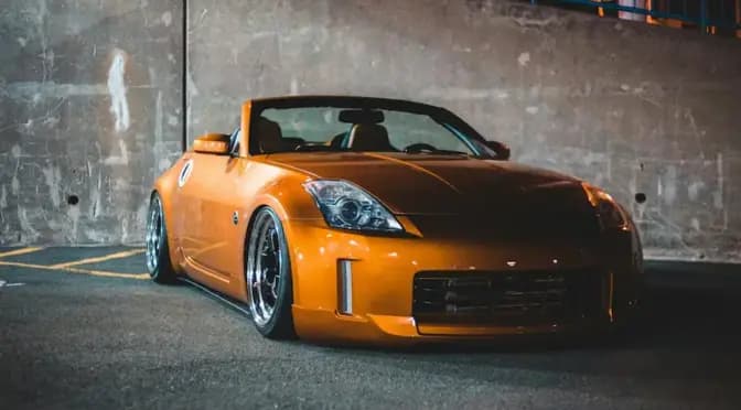 Auto gialla leggermente modificata con assetto ribassato e cerchi sportivi, parcheggiata all’aperto
